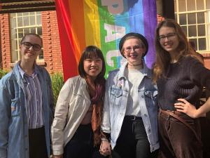 Students in front of rainbow flag
